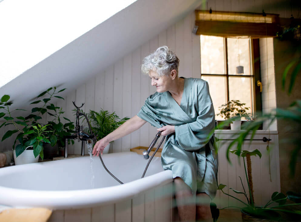 seniorin-sitzt-auf-Badewannenrand