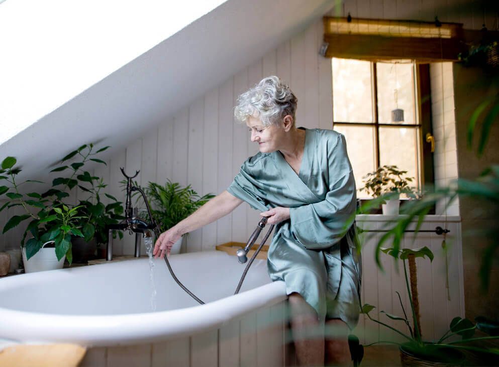 seniorin-sitzt-auf-Badewannenrand
